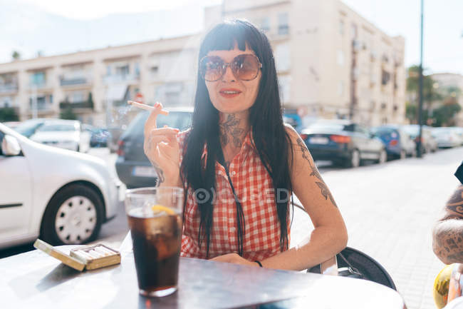 Maduro fêmea hipster fumar cigarro no café calçada — Fotografia de Stock