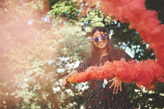 Young woman holding red smoke flare — Stock Photo