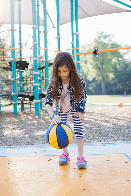 Young Girl Bouncing Basketball In Playground Playing Childhood Stock Photo