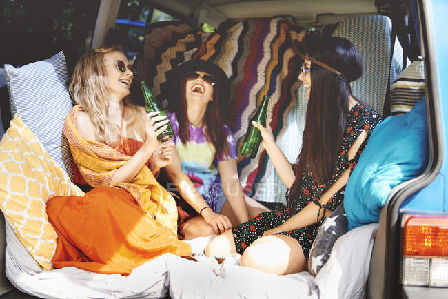 Three young boho women laughing in recreational van — Stock Photo