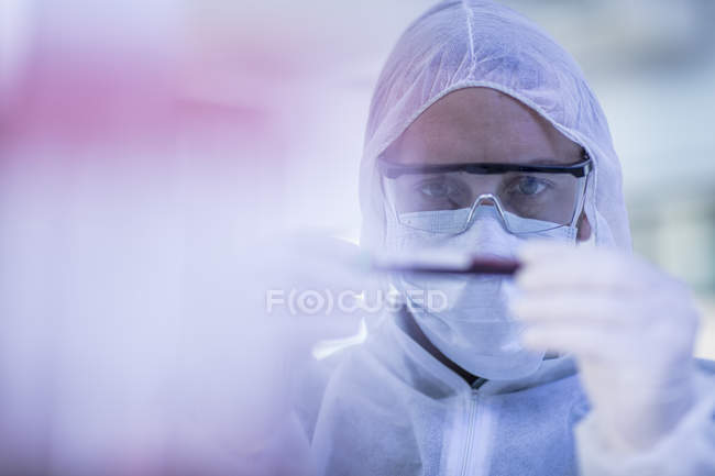 Trabalhador de laboratório examinando tubo de ensaio — Fotografia de Stock