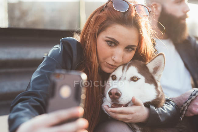 Молода жінка, беручи selfie з собакою — стокове фото