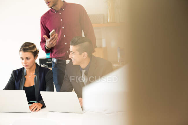 Businesswoman and men having meeting at office desk — Stock Photo