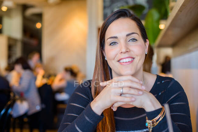 Portrait of happy woman with hands together, wearing engagement ring — Stock Photo
