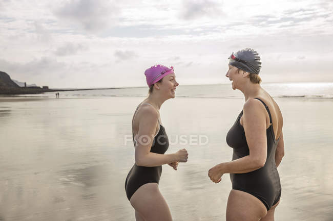Side view of mother and daughter laughing on beach — Stock Photo