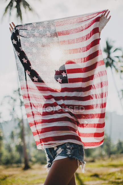 Junge Frau hält amerikanische Flagge hoch, Krabi, Thailand — Stockfoto