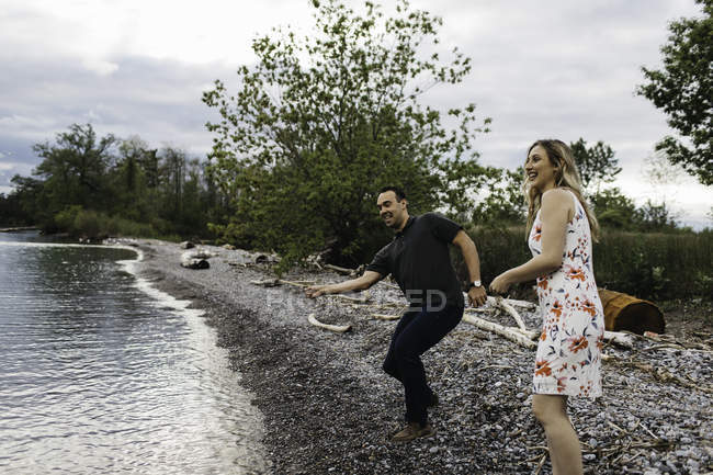 Couple skimming stones on beach, Oshawa, Canada — Stock Photo