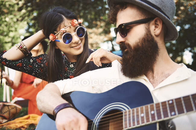 Jovem boho casal tocando guitarra acústica no festival — Fotografia de Stock