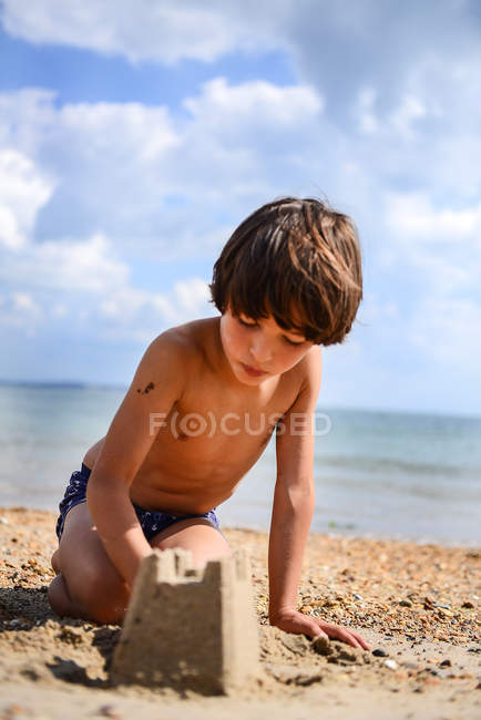 Vue rapprochée de garçon faisant le château de sable sur la plage — Photo de stock
