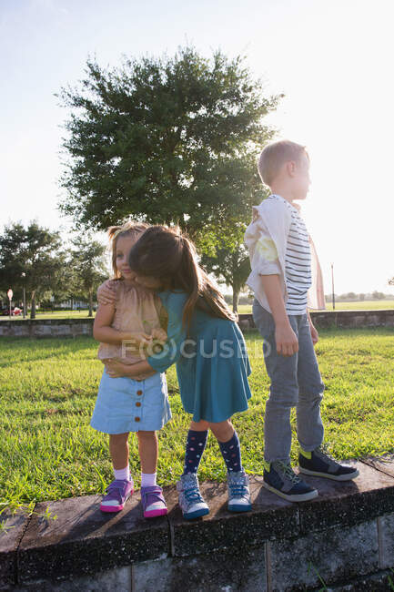 Brother with sisters in park — Stock Photo
