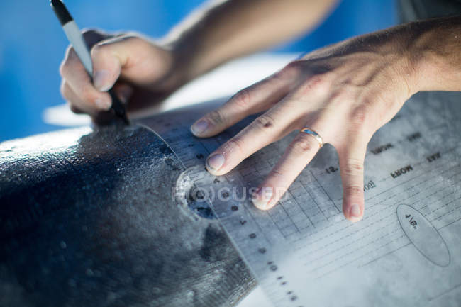 Close-up view of man taking measurements to make paddle board — Stock Photo