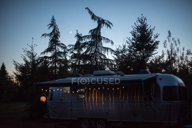 Camper van in ambiente rurale al crepuscolo, illuminato da luci fatate — Foto stock