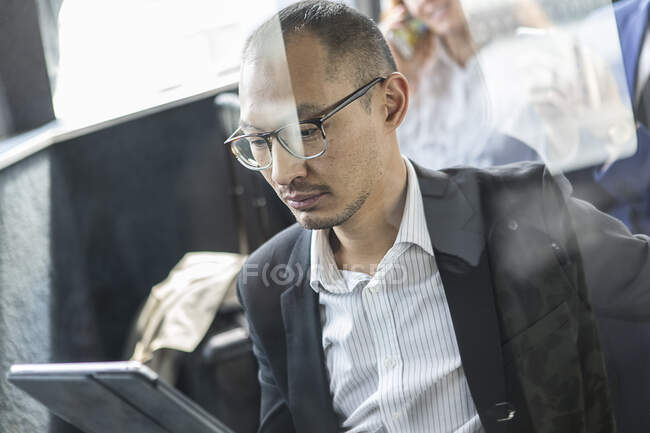 Бізнесмен дивиться на цифровий планшет на пасажирському поромі — стокове фото