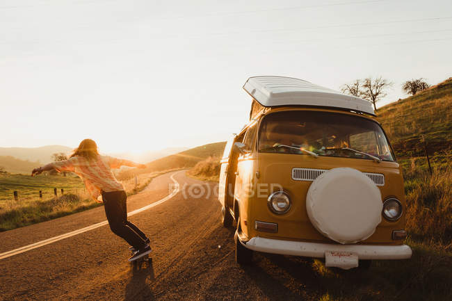 Jeune skateboard masculin sur route rurale au coucher du soleil, Exeter, Californie, USA — Photo de stock
