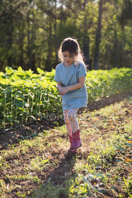 Young girl walking on farm, holding hands together — Stock Photo