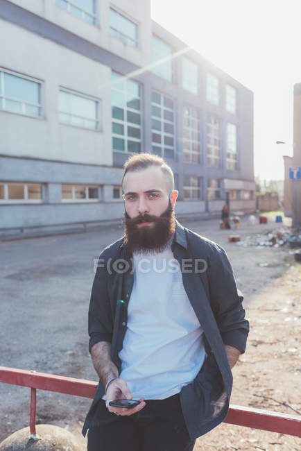 Portrait d'un homme barbu tenant un smartphone — Photo de stock