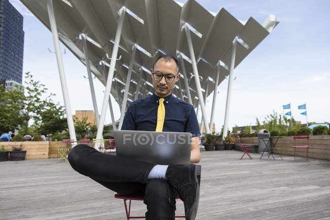 Businessman using laptop outside hotel — Stock Photo