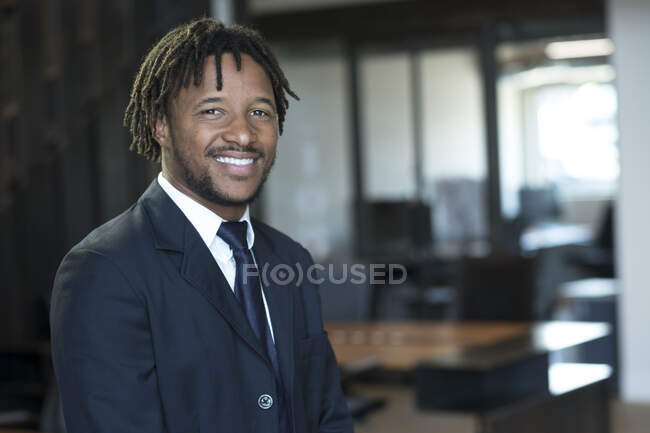 Портрет молодого бізнесмена в офісі, посміхаючись — стокове фото