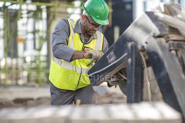 Trabajador de la construcción usando maquinaria pesada - foto de stock