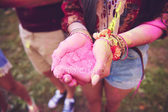 Pink chalk cupped in young woman's hands at festival — Stock Photo