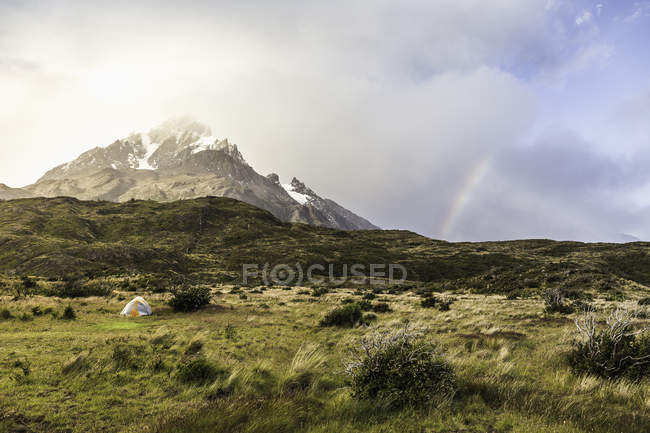 Горный пейзаж с палаткой и радугой, национальный парк Торрес-дель-Пайне, Чили — стоковое фото