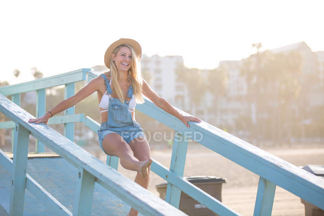 Молодая женщина валяет дурака на пляже рампы, Санта-Моника, Калифорния, США — стоковое фото