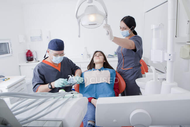 Dentist and dental nurse with patient — Stock Photo