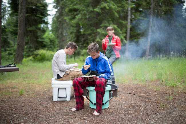 Family in rural setting, camping, eating meal — Stock Photo