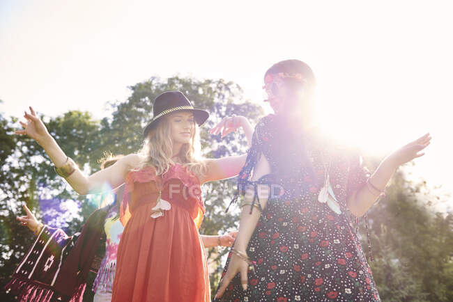 Two young boho women dancing in sunlight at festival — Stock Photo