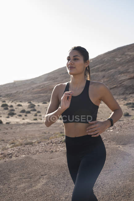 Young female running in arid landscape, Las Palmas, Canary Islands, Spain — Stock Photo