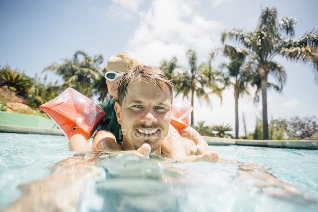 Retrato de padre e hijo en piscina - foto de stock
