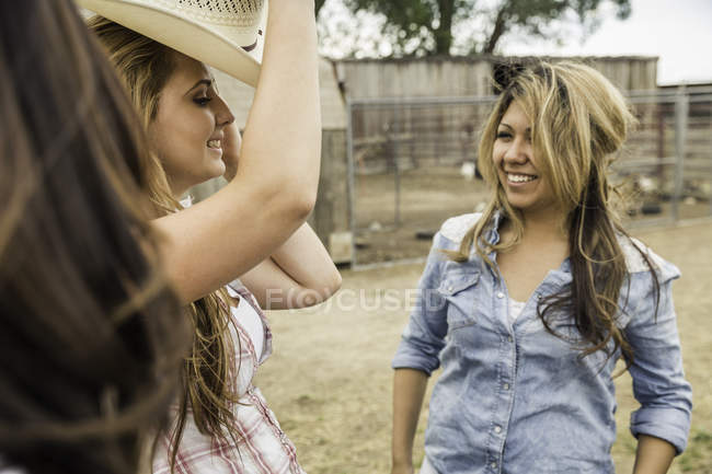 Tres mujeres juntas en la granja, hablando, sonriendo - foto de stock