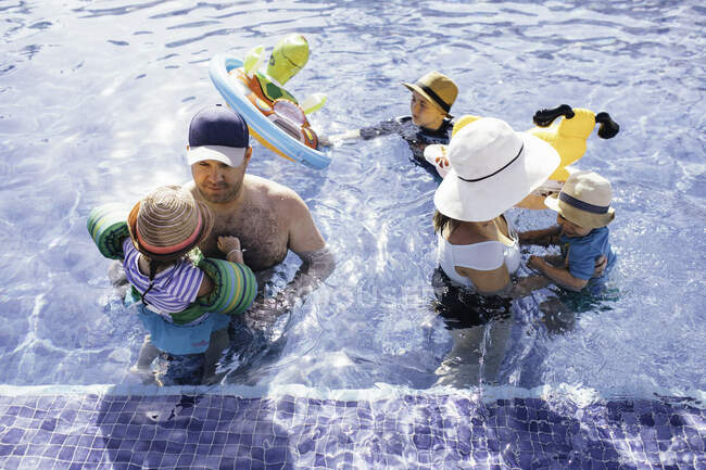 Family swimming in outdoor swimming pool — Stock Photo