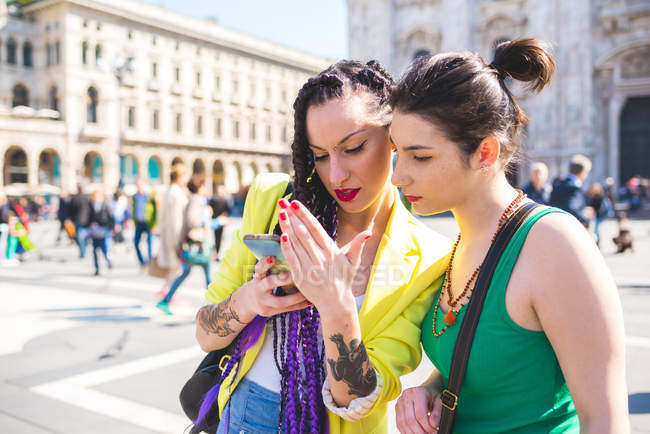 Mulheres usando smartphone fora, Il Duomo, Milão, Itália — Fotografia de Stock