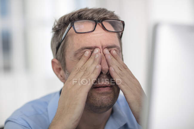 Homme stressé frottant les yeux — Photo de stock