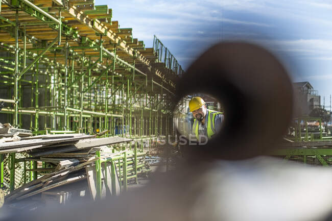 Trabalhador da construção olhando através da tubulação — Fotografia de Stock