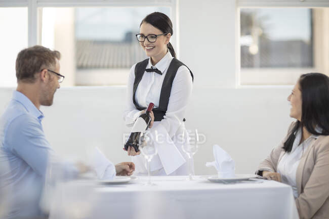 Waitress showing bottle of wine to diner in restaurant — Stock Photo