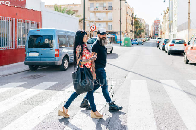 Mature hipster couple on pedestrian crossing — Stock Photo