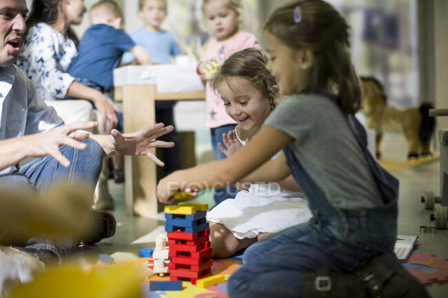 Teacher and children playing with building blocks — Stock Photo