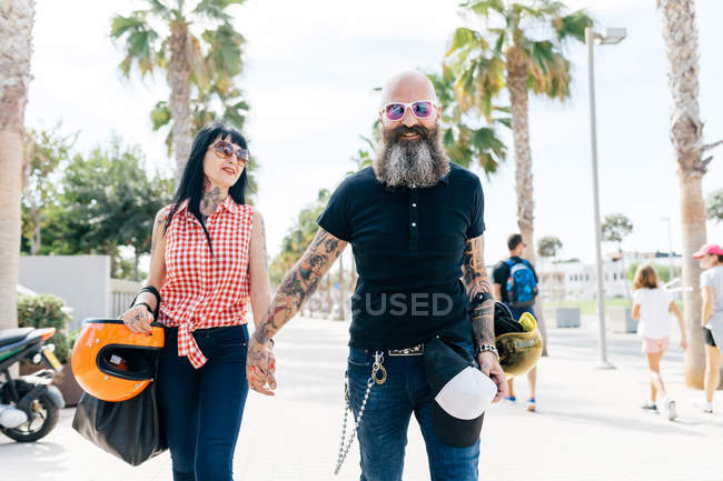 Портрет взрослой пары хипстеров, прогуливающейся по тротуару, Валенсия, Испания — стоковое фото