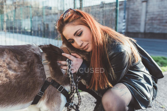 Mujer pelirroja abrazando perro - foto de stock
