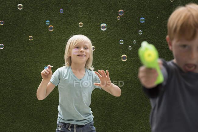 Chicos usando fabricante de burbujas - foto de stock