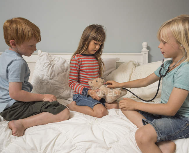 Kinder spielen mit Stethoskop und Stofftier — Stockfoto