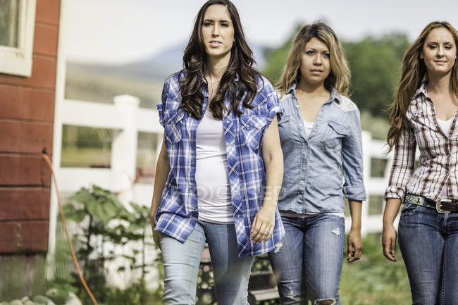 Portrait de trois jeunes femmes à la ferme, marchant ensemble — Photo de stock