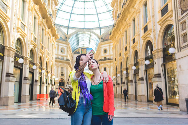 Mujeres tomando selfie en Galleria Vittorio Emanuele II, Milan, Italia - foto de stock