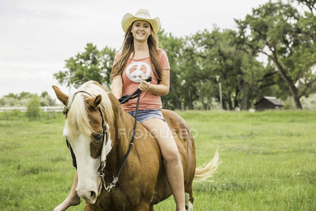 Portrait of young woman riding horse — Stock Photo