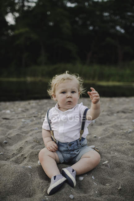Портрет мальчика, сидящего на песчаном пляже, озеро Онтарио, Канада — стоковое фото