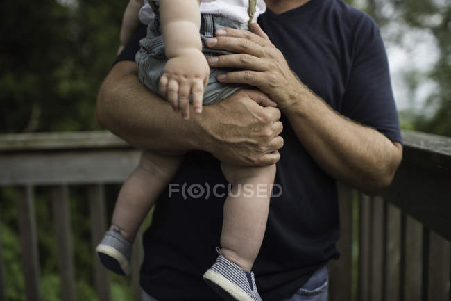 Mid section of man carrying toddler son on balcony — Stock Photo