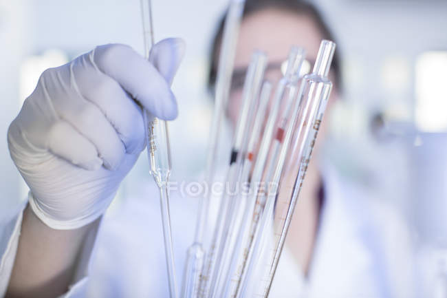 Trabalhador de laboratório escolhendo pipeta, close-up — Fotografia de Stock