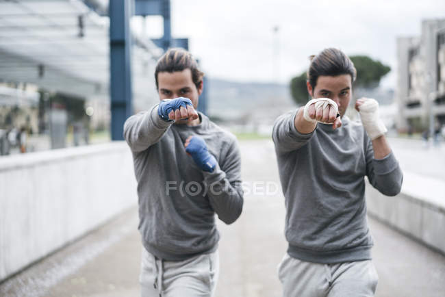 Identical male boxers training outdoors — Stock Photo